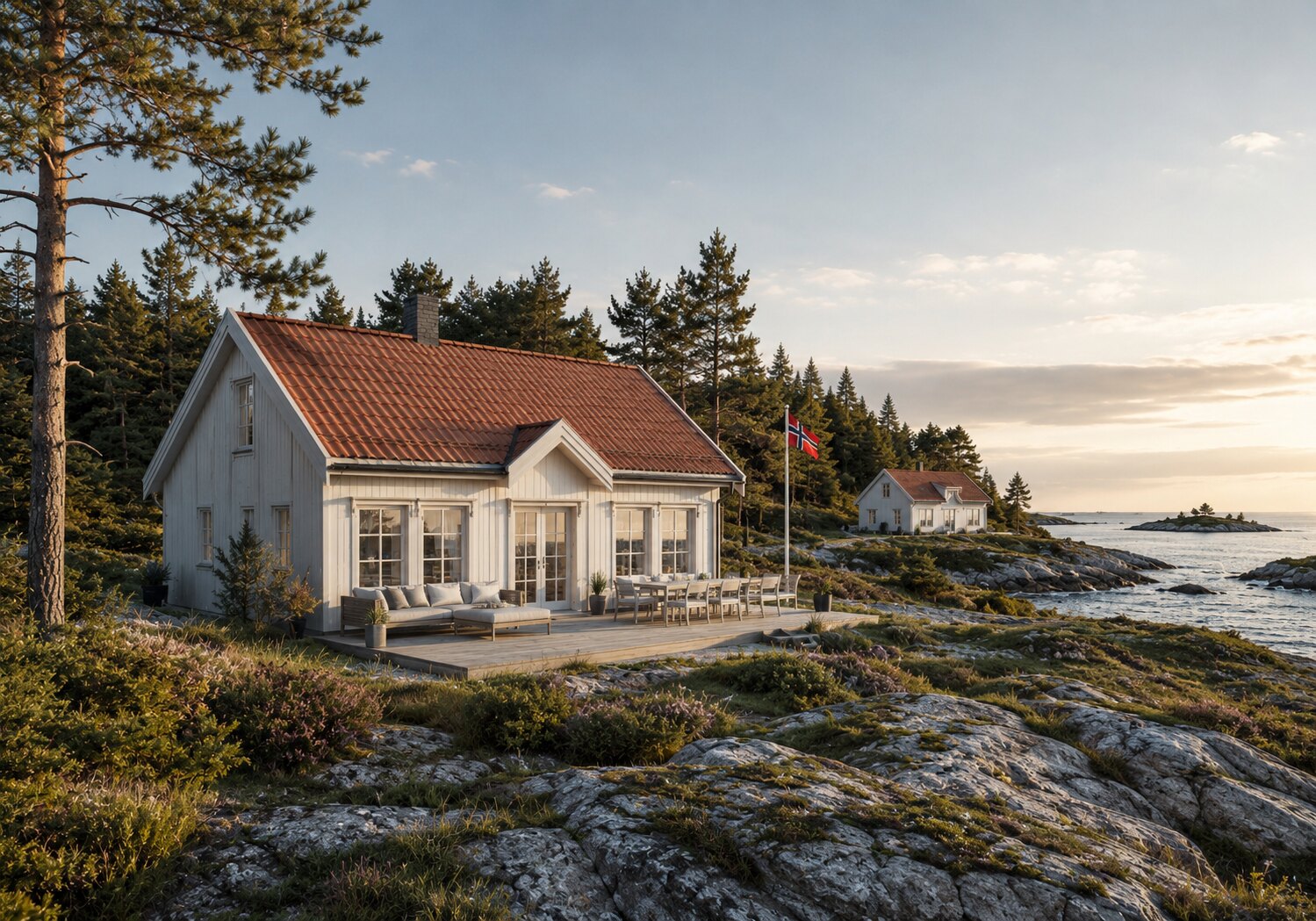 Klassisk hvit hytte med rød takstein ved sjøen
